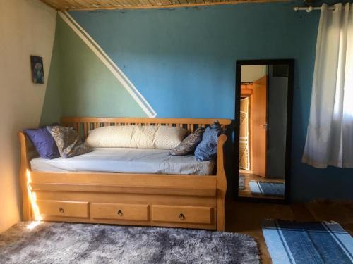 1 dormitorio con cama de madera y espejo en Vila da Mata - Bambu House en Alto Paraíso de Goiás