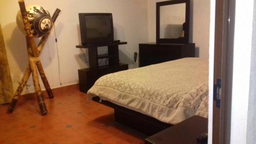 a bedroom with a bed and a television and a tripod at Hotel Rancho el Paraíso in Valle de Bravo