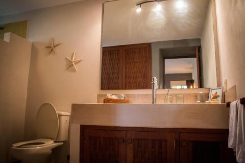 a bathroom with a sink and a toilet and a mirror at Residencial Los Mangos - Departamento 205 in Zihuatanejo