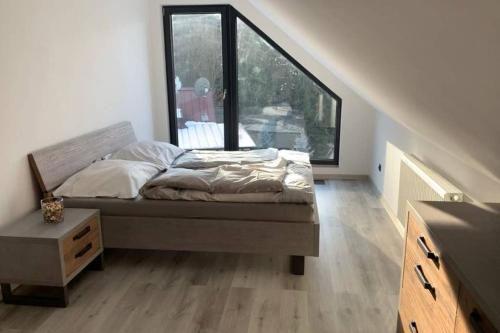 a bed in a room with a large window at Apartmán Peklo in Vrchlabí