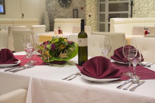 a bottle of wine sitting on a table with wine glasses at Hotel Talija in Banja Luka