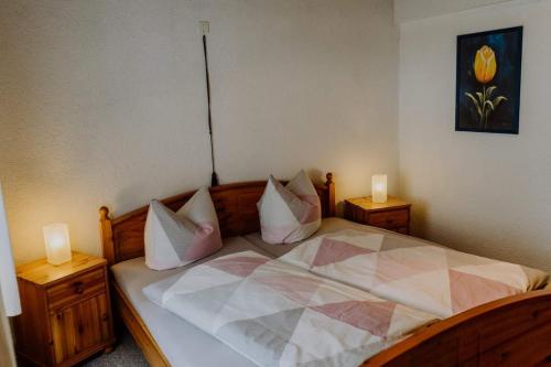 ein Schlafzimmer mit einem großen Bett mit zwei Leuchten in der Unterkunft Ferienhaus Schreinert in Breitenbrunn