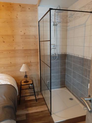 una ducha con puerta de cristal en un dormitorio en La Maison Trésallet, en La Plagne Tarentaise