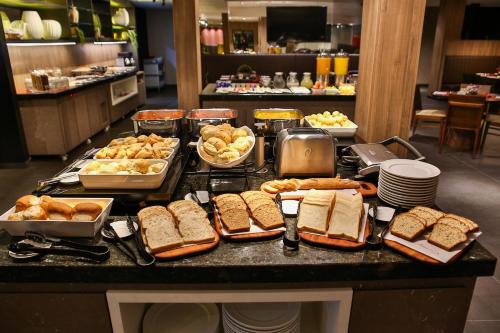 a buffet with sandwiches and other foods on a counter at Quality Hotel Blumenau in Blumenau