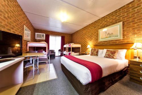 a hotel room with a large bed and a desk at Central Yarrawonga Motor Inn in Yarrawonga