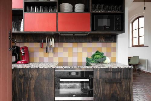 a kitchen with red cabinets and a counter with vegetables at De Pannenbakkerij in Kruishoutem
