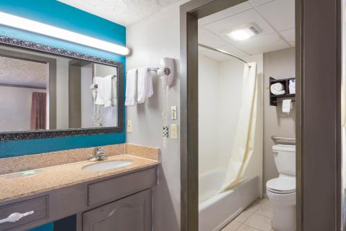 a bathroom with a sink and a mirror and a toilet at Econo Lodge Inn & Suites in Oklahoma City