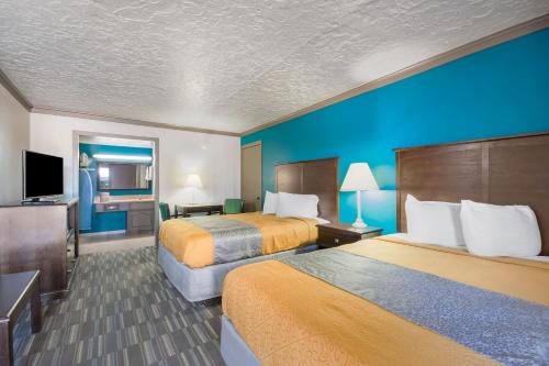 a hotel room with two beds and a flat screen tv at Econo Lodge Inn & Suites in Oklahoma City