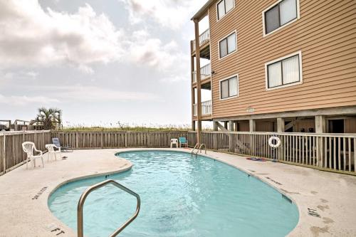 a swimming pool in front of a building at Oceanfront Carolina Beach Condo with Pool and Views! in Carolina Beach