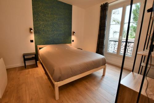 オーヴェル・シュル・オワーズにあるLA LOGE DU MONTCEL - T2 -1er étageの窓付きの部屋にベッド付きのベッドルーム1室があります。