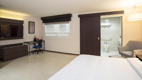 a hotel room with a bed and a bathroom at Holiday Inn Express - Mexico Basilica by IHG in Mexico City
