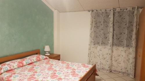 Schlafzimmer mit einem Bett und einem Fenster in der Unterkunft Apartment Lake Maggiore - Gelsomino in Maccagno Inferiore