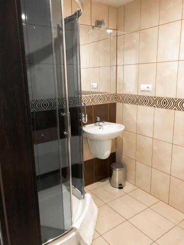 a bathroom with a shower and a sink at Gościniec Młyn in Chodecz