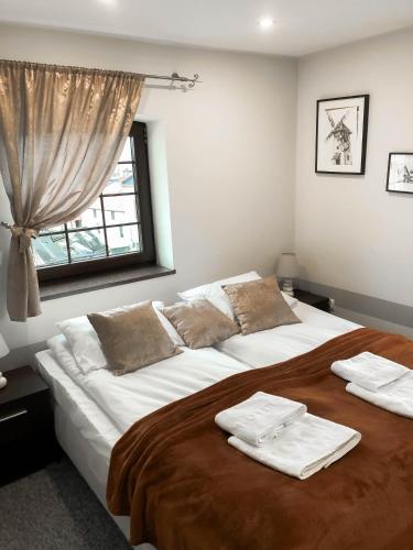 a bedroom with a large bed with towels on it at Gościniec Młyn in Chodecz
