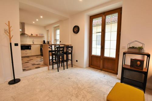 une cuisine et une salle à manger avec une table et des chaises dans l'établissement LE COTTAGE AUVERSOIS - Rdc -T2 -, à Auvers-sur-Oise