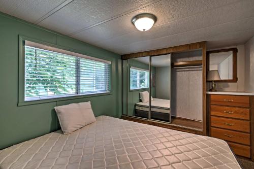 Schlafzimmer mit einem Bett und einem Spiegel in der Unterkunft Cozy Middle Bass Cabin with Grill and Lagoon Access! in Put-in-Bay