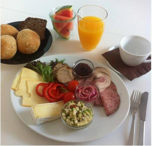 a plate of food with cheese and vegetables on a table at Hotel Phønix in Holstebro