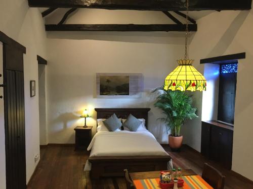 a bedroom with a bed and a yellow lamp at Casa Aranjuez in Bogotá