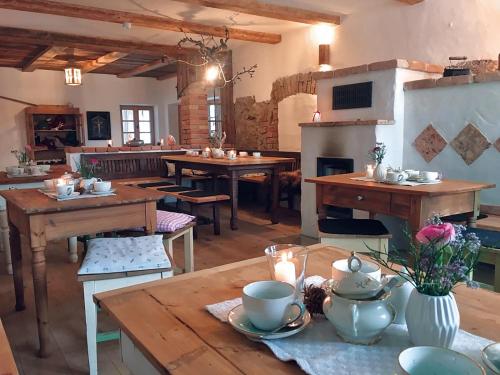 Habitación con mesas de madera y chimenea en la cocina. en Appartement - Ferienwohnung - FeWo Heuboden en Emmering