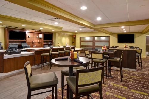 a restaurant with tables and chairs and a bar at Holiday Inn Cincinnati-Riverfront by IHG in Covington