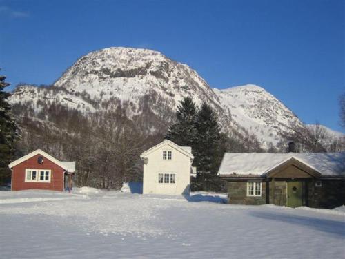 a snow covered mountain with two buildings and a house at Seim Camping - Røldal in Røldal