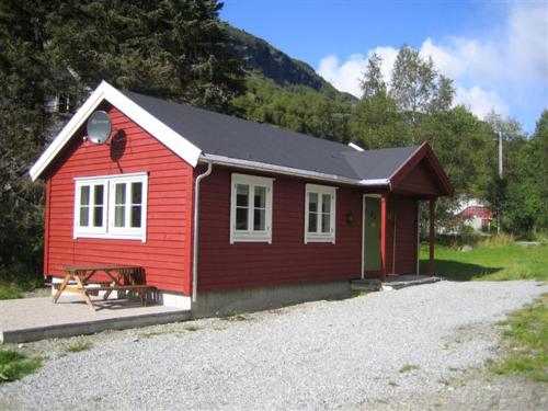 a red house with a picnic table in front of it at Seim Camping - Røldal in Røldal