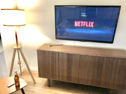 a flat screen tv sitting on top of a wooden entertainment center at Apartament RadMila2 in Radom