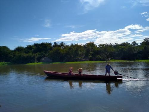 three people are rowing a boat on a lake at Casa Kukama Lodge in Iquitos