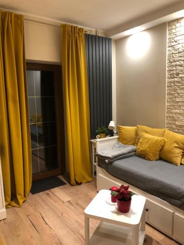1 dormitorio con cortinas amarillas, 1 cama y 1 mesa en Nowoczesny pokój w spokojnej okolicy, en Chełmno