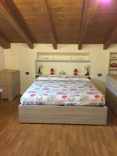 un grande letto in una camera da letto con soffitto in legno di Casa Grazia a Magreglio