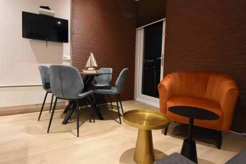 a living room with a table and chairs and a television at Houseboat Martinique in Maastricht
