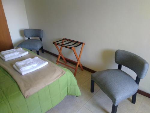 a room with two chairs and a bed and a chair at Don Alfonso Departamento in San Carlos de Bariloche