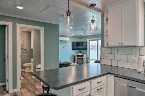 a kitchen with white cabinets and a black counter top at The Lakefront Home - 5 Minutes From Detroit Lakes! in Detroit Lakes