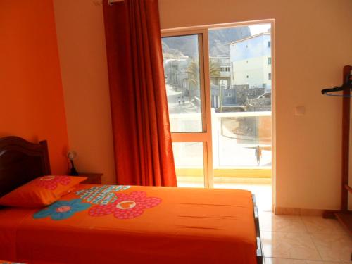 a bedroom with a bed and a large window at Casa Celeste in Ponta do Sol