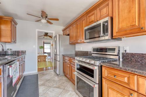 a kitchen with wooden cabinets and stainless steel appliances at New Belmont Shore Retreat with free Parking Walk to Beaches in Long Beach