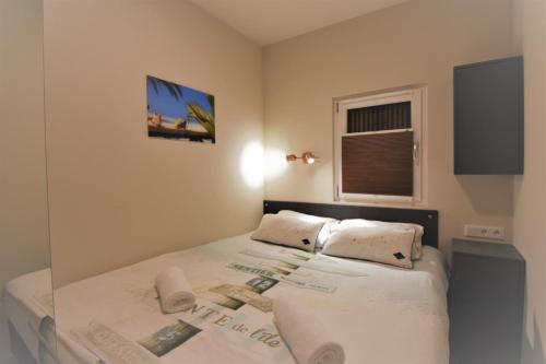 een slaapkamer met een bed met witte lakens en kussens bij Houseboat Martinique in Maastricht