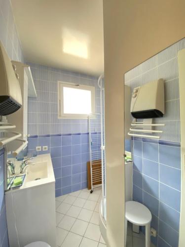 コトレにあるCauterets T2 avec toit terrasse, parking couvertの青いタイル張りのバスルーム(洗面台、トイレ付)
