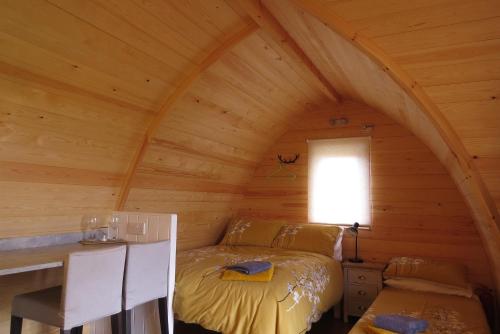 a bedroom with a bed in a wooden cabin at Archers Meadow Shropshire in Ellesmere