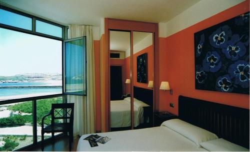 a bedroom with a bed and a view of the ocean at Hotel la Concha de Suances in Suances