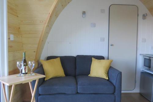 a blue couch with yellow pillows and a table at Archers Meadow Shropshire in Ellesmere