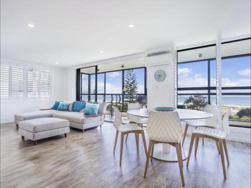 a living room with a couch and a table and chairs at Kirra Waves in Gold Coast