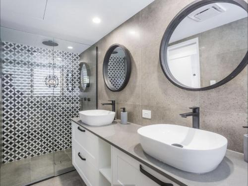 a bathroom with two sinks and a mirror at Kirra Waves in Gold Coast