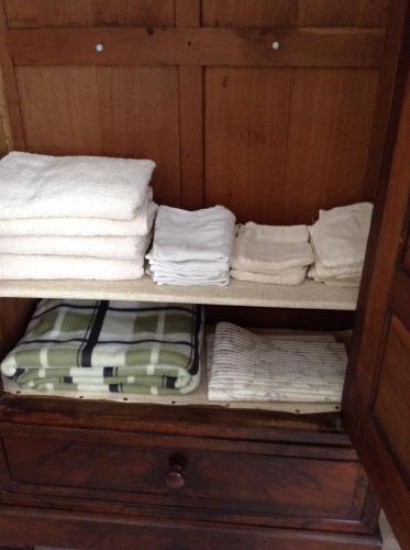 - une étagère avec des serviettes et des serviettes pliées dans l'établissement French Holiday Accommodation, à Bort-les-Orgues