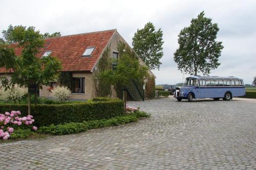 a blue bus parked in front of a house at Holiday Home De Colve in Bruges