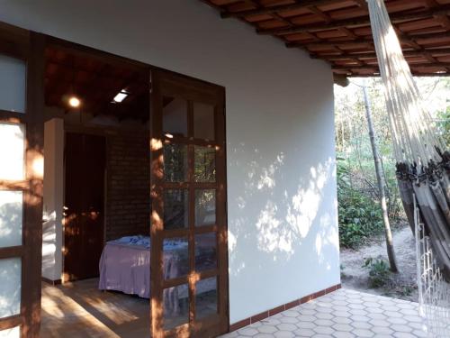 a room with a bed and a glass door at Chalé da Mangueira in Vale do Capao