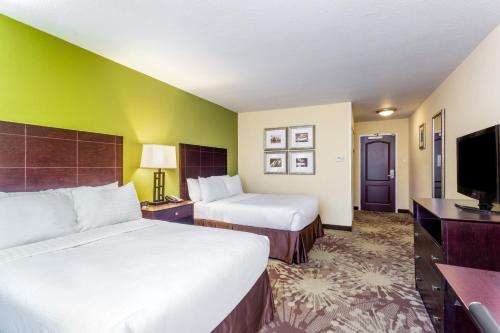 a hotel room with two beds and a flat screen tv at Hotel Gurnee in Gurnee