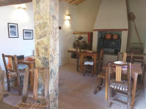 a dining room with tables and chairs and a stove at Sendero De Las Cabras in Purmamarca