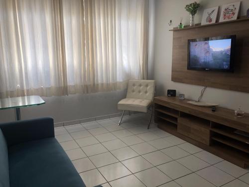 sala de estar con TV y silla en Apt. Completo em Recife, Boa Viagem - 2 qts - p/ 5 pessoas - 200m da praia, en Recife