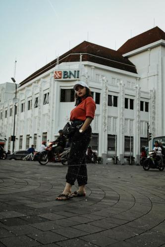 a woman talking on a cell phone in front of a building at Griya Suryo Wijilan in Yogyakarta