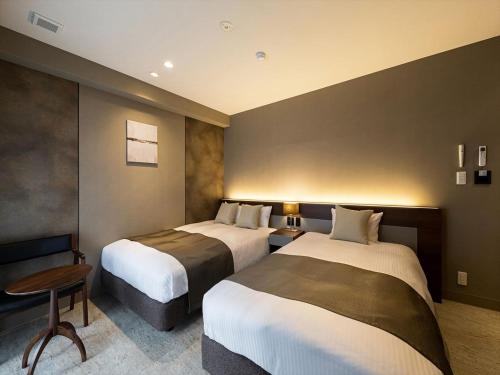 Ένα ή περισσότερα κρεβάτια σε δωμάτιο στο HOTEL SHINPOIN OSAKA